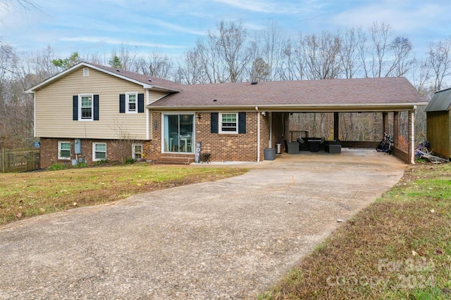 tri-level home featuring a carport and a front lawn