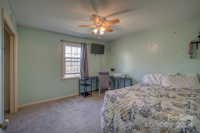 bedroom with ceiling fan, light colored carpet, and a textured ceiling