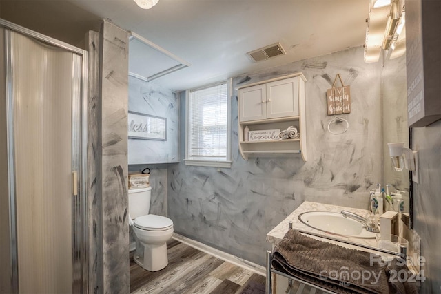 bathroom with vanity, hardwood / wood-style flooring, toilet, and walk in shower