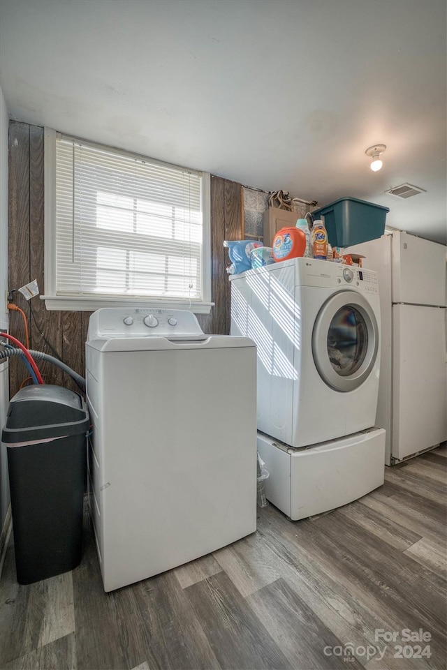 laundry area with separate washer and dryer and wood-type flooring