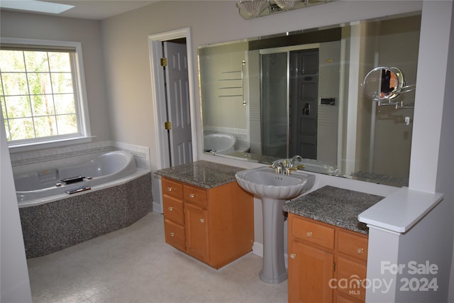 bathroom with a skylight and independent shower and bath