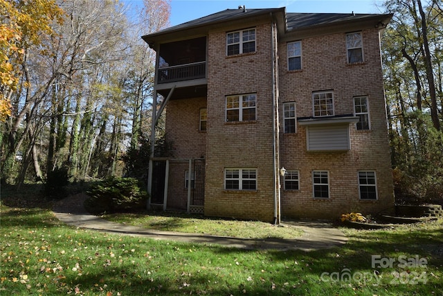 rear view of house featuring a lawn