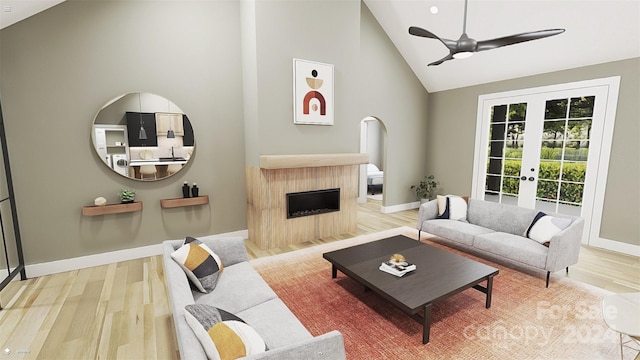 living room with hardwood / wood-style flooring, ceiling fan, high vaulted ceiling, and french doors