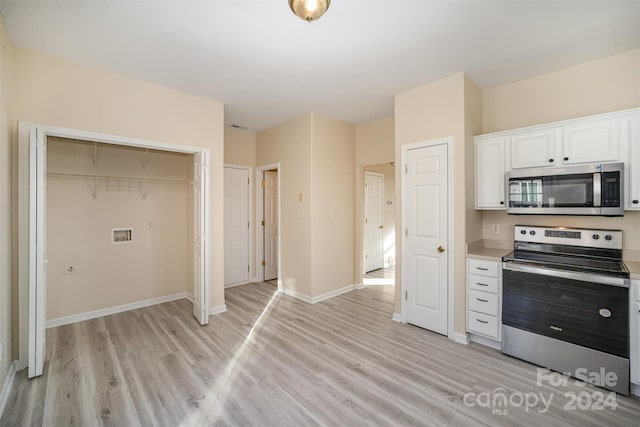 kitchen featuring white cabinets, stainless steel appliances, and light wood-type flooring