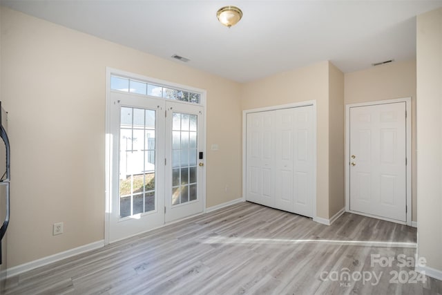 unfurnished bedroom featuring access to exterior, light wood-type flooring, and a closet