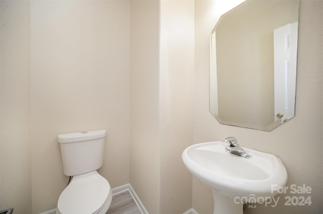 bathroom featuring hardwood / wood-style floors, toilet, and sink