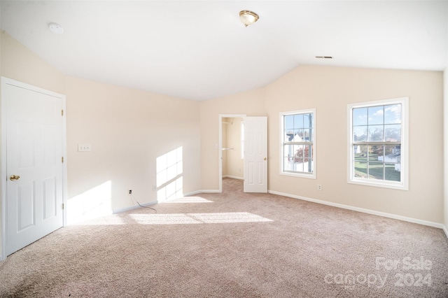 empty room with light carpet and vaulted ceiling