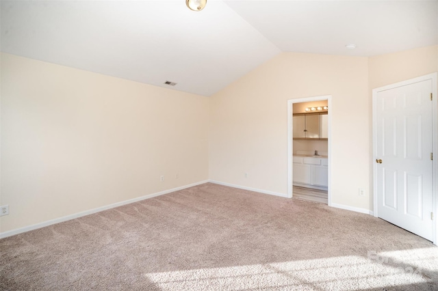 unfurnished bedroom featuring carpet, vaulted ceiling, and ensuite bath