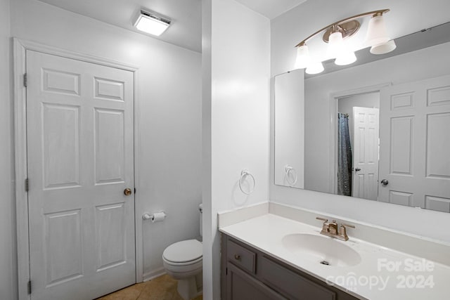 bathroom featuring tile patterned flooring, vanity, and toilet