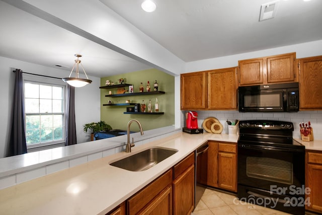 kitchen featuring pendant lighting, backsplash, black appliances, sink, and light tile patterned flooring