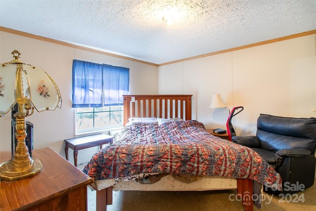 bedroom with crown molding, carpet floors, and a textured ceiling