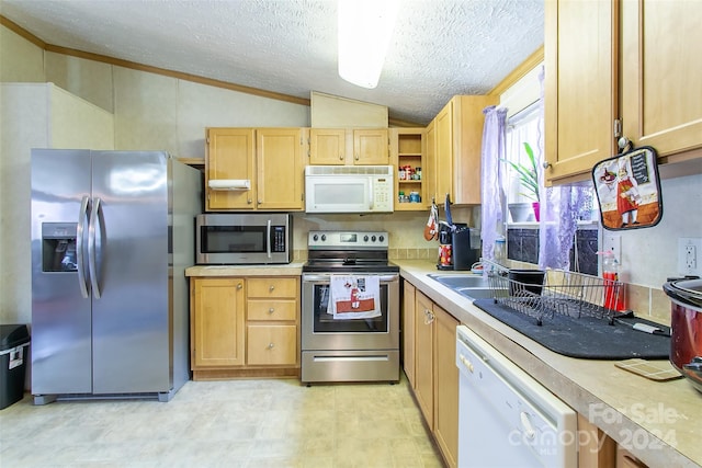 kitchen with appliances with stainless steel finishes, a textured ceiling, vaulted ceiling, and light brown cabinets