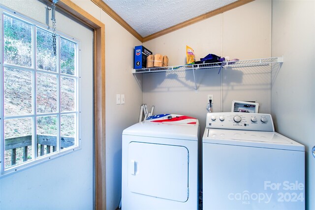 washroom featuring crown molding, washer and clothes dryer, and a textured ceiling