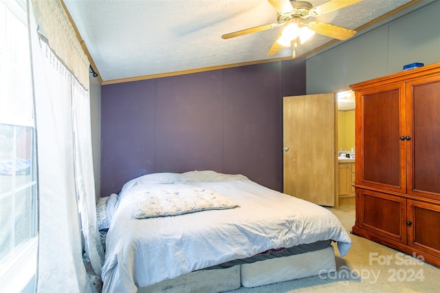 carpeted bedroom with a textured ceiling, ceiling fan, and ornamental molding