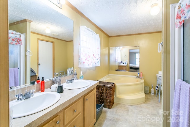 bathroom featuring vanity, a textured ceiling, a bathtub, and crown molding