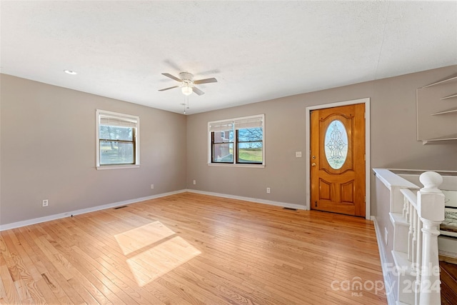 entrance foyer featuring ceiling fan, light wood-type flooring, and a textured ceiling