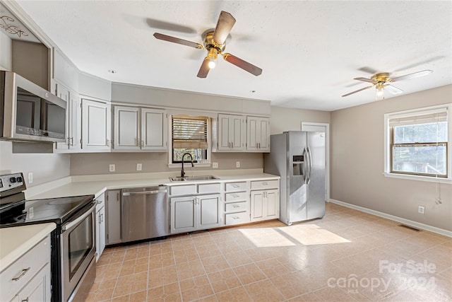 kitchen featuring ceiling fan, sink, stainless steel appliances, and a textured ceiling