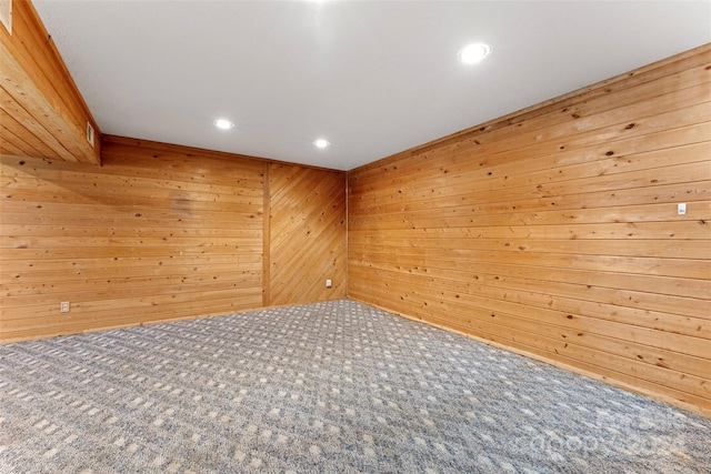 spare room with wood walls and carpet