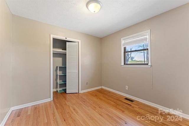 unfurnished bedroom featuring light wood-type flooring and a closet