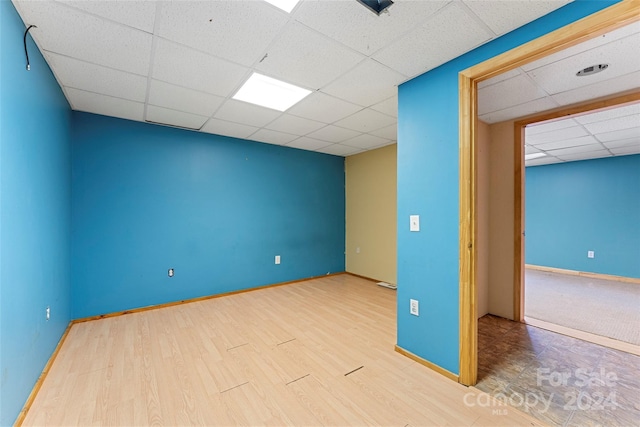 unfurnished room with hardwood / wood-style floors and a paneled ceiling