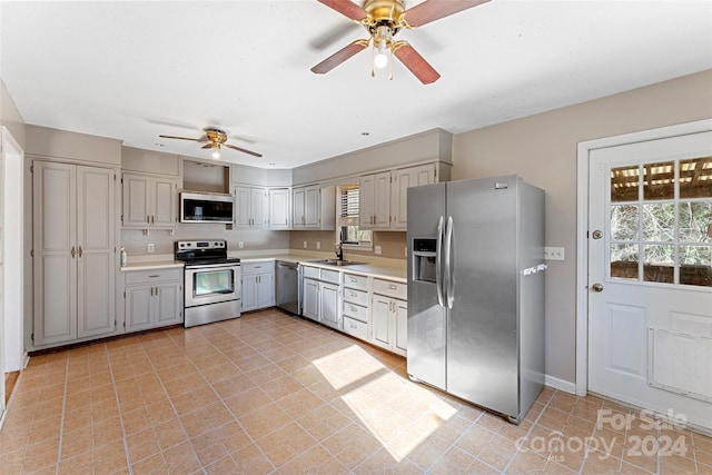 kitchen with ceiling fan, sink, light tile patterned floors, and stainless steel appliances