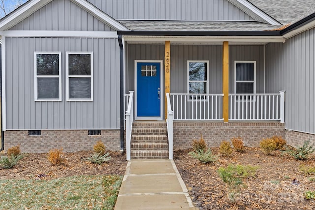 view of exterior entry featuring covered porch