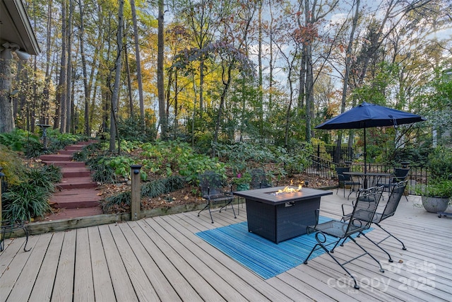 deck featuring an outdoor fire pit, outdoor dining area, and stairway