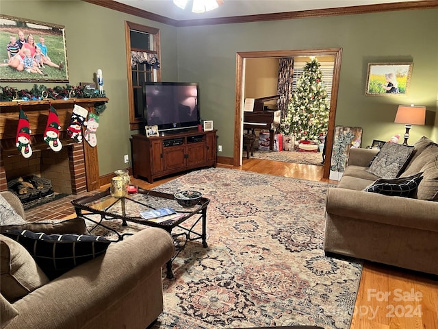 living room with a fireplace, hardwood / wood-style flooring, and ornamental molding