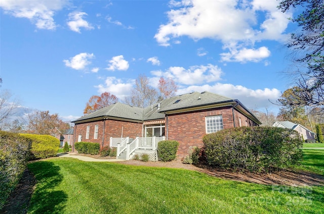 back of house featuring a deck and a lawn