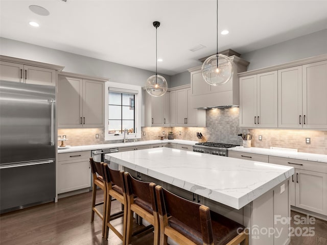 9 Haverhill Way, Arden, NC 28704 - kitchen featuring built in refrigerator, custom range hood, a kitchen breakfast bar, a center island, and tasteful backsplash