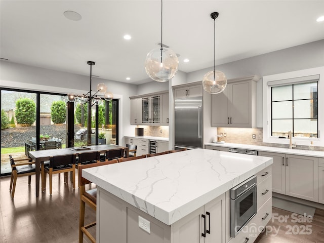 9 Haverhill Way, Arden, NC 28704 - kitchen with built in appliances, a kitchen island, decorative backsplash, wood finished floors, and recessed lighting