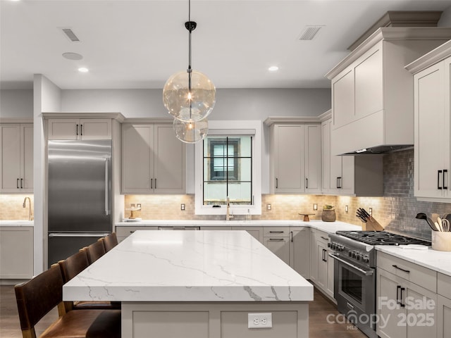9 Haverhill Way, Arden, NC 28704 - kitchen with high end appliances, a sink, a center island, tasteful backsplash, and dark wood-style floors