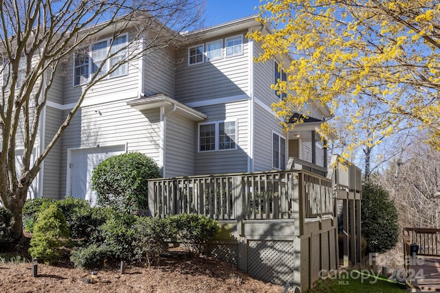 view of home's exterior with a wooden deck and a garage