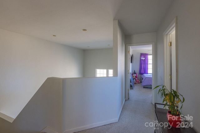 corridor featuring light colored carpet