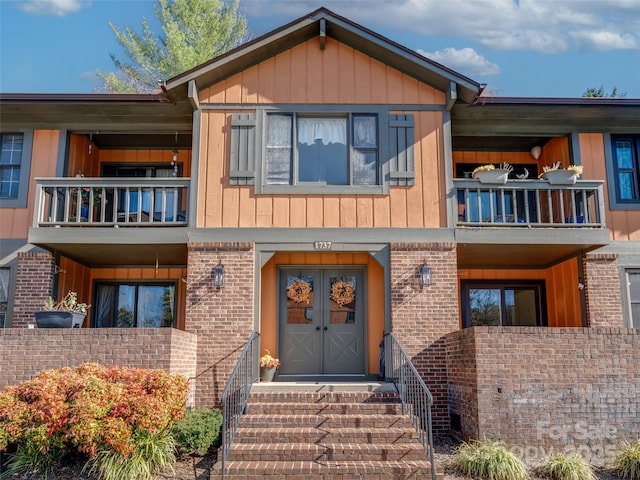 view of front of property featuring a balcony and french doors