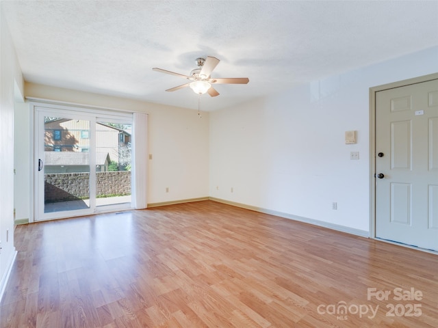 spare room with ceiling fan, a textured ceiling, and light wood-type flooring