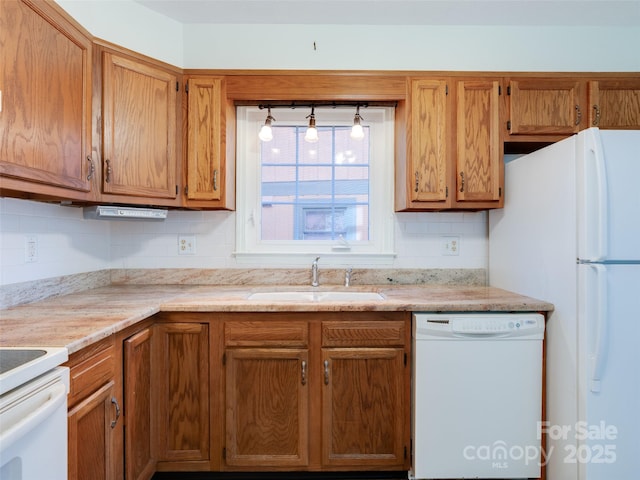 kitchen with decorative backsplash, sink, and white appliances