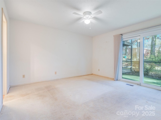 carpeted spare room featuring ceiling fan