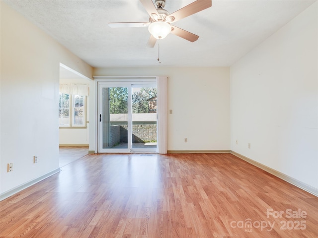 spare room featuring ceiling fan, light wood-type flooring, and a textured ceiling