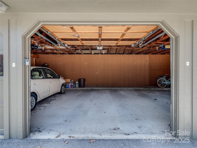 garage featuring a garage door opener and wood walls