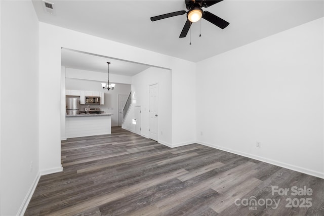 unfurnished living room with dark hardwood / wood-style flooring and ceiling fan with notable chandelier