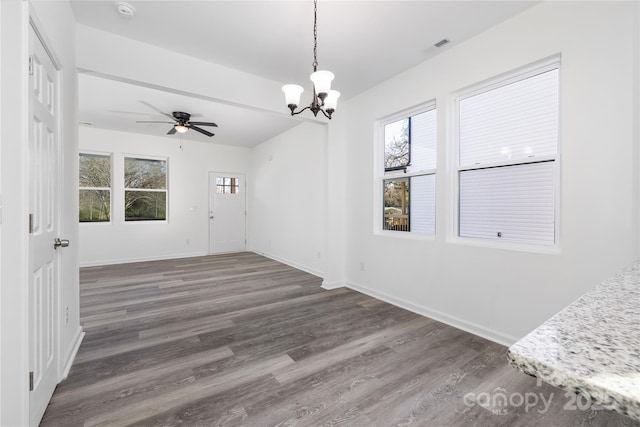 empty room with dark hardwood / wood-style floors and ceiling fan with notable chandelier