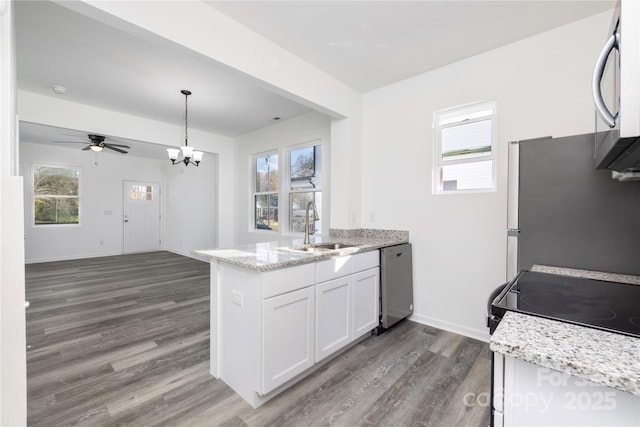 kitchen with sink, white cabinetry, appliances with stainless steel finishes, kitchen peninsula, and pendant lighting