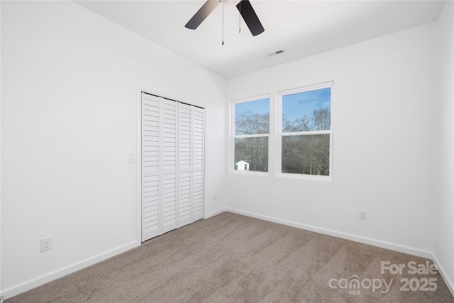 unfurnished bedroom featuring ceiling fan, a closet, and carpet