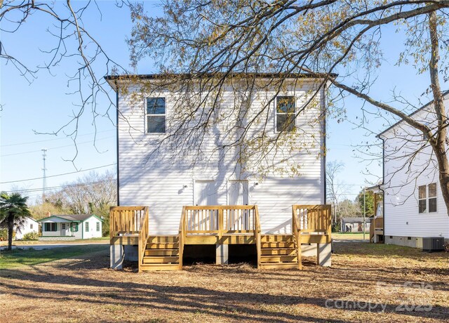 back of property with central AC unit and a deck