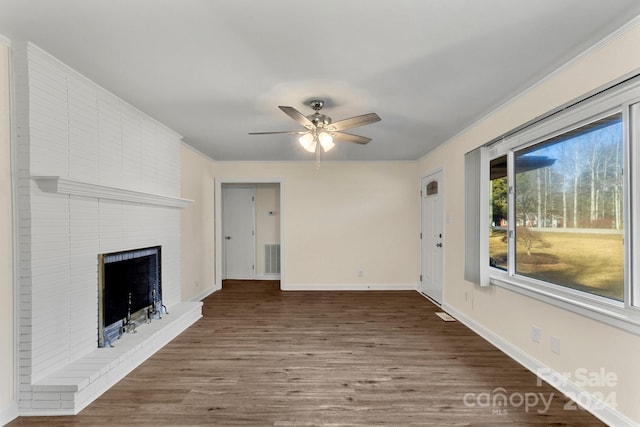 unfurnished living room with dark hardwood / wood-style flooring, a brick fireplace, and ceiling fan