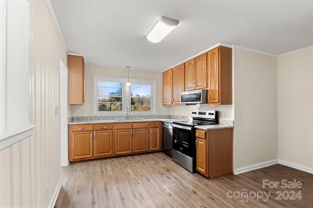 kitchen featuring pendant lighting, sink, light hardwood / wood-style flooring, ornamental molding, and appliances with stainless steel finishes