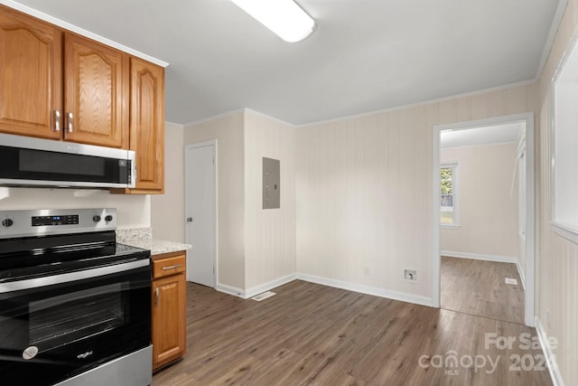 kitchen with appliances with stainless steel finishes, electric panel, hardwood / wood-style flooring, and crown molding