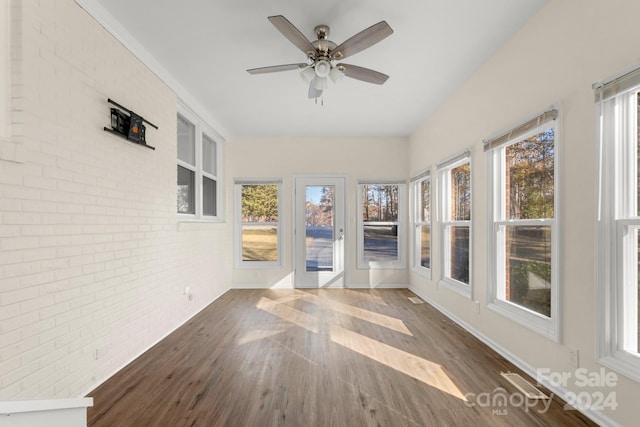 unfurnished sunroom with ceiling fan