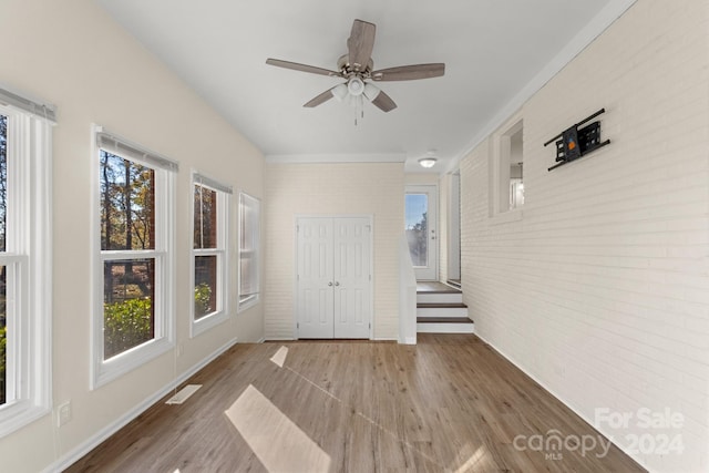 unfurnished sunroom with ceiling fan